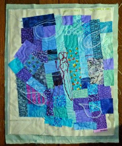 Stitched dragonfly and random satin-stitched shapes, free motion quilted.