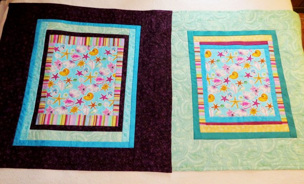Two lap quilts featuring the same central fabric.