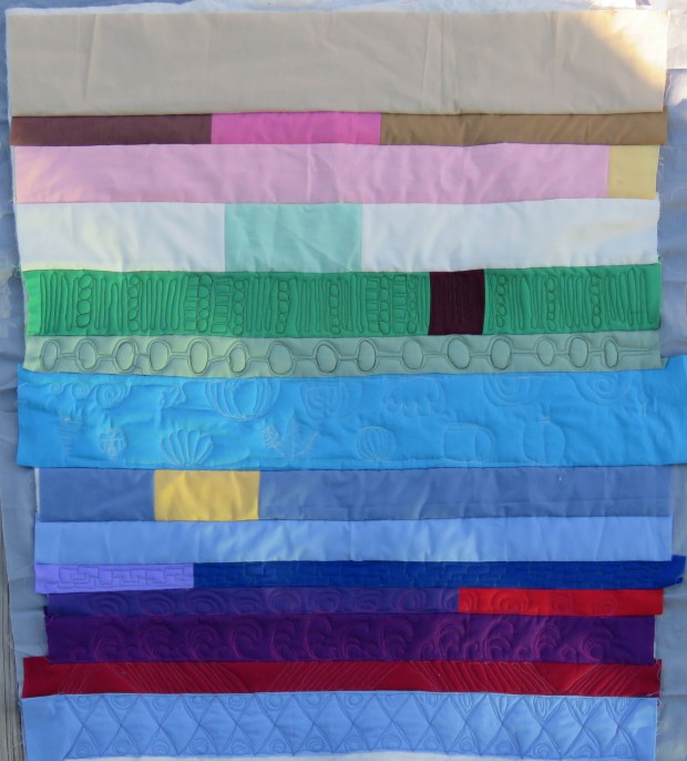 Strippy mini-quilt with about half the rows quilted.