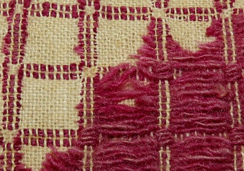 This close-up shows why this weave structure is called "overshot." The red pattern threads are floating over the plain weave ground, tied down at intervals to keep them in place. But if you were to remove all of them, you would still have a viable cloth.