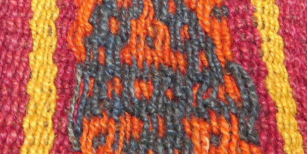 The orange and navy threads float along the surface, while the red and yellow threads intersect with the weft at shorter intervals.
