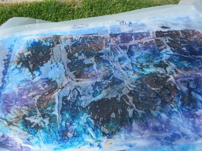 Plastic sheeting on top of dyed fabric.