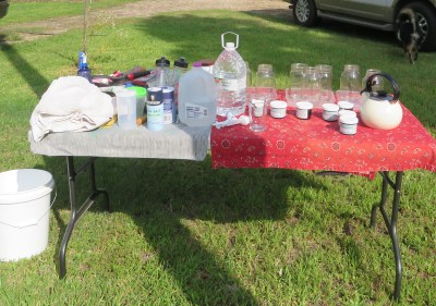 Supply table with dyes, jars, measuring spoons, water, etc.