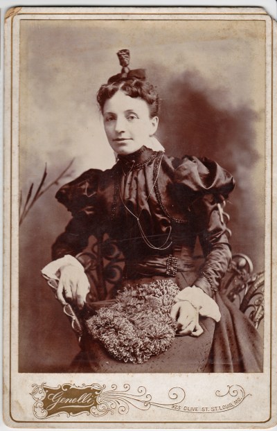 I love this confident-looking woman. Her topknot hairdo says 1890s. What is that on her lap?!! It looks like a bag made from individual silk flowers.