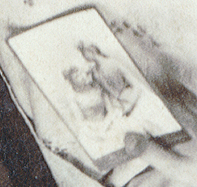 This is the picture that the woman in white is holding. Is it these same two women in an earlier picture? Or absent friends, or sisters, that they wanted to include in their portrait?