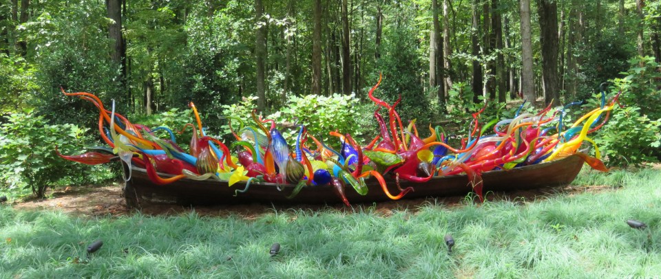 Dale Chihuly's Fiori Boat, a boat in the forest, filled with glass forms