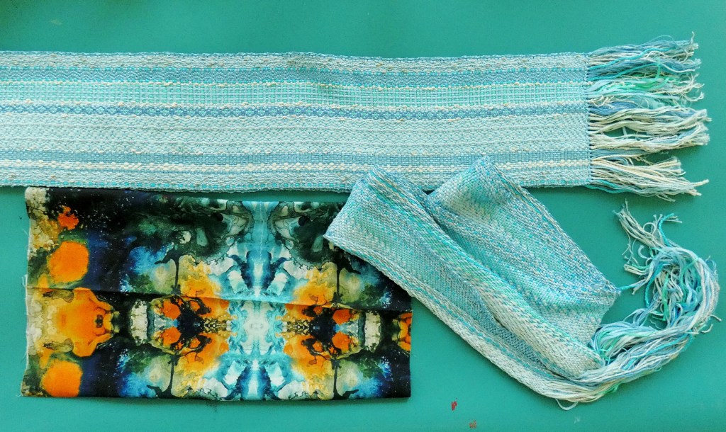 two handwoven scarves and one piece of printed fabric
